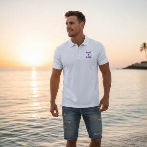 Man wearing the Salt & Soil Signature Men’s Polo – White Edition standing near the beach during sunset.